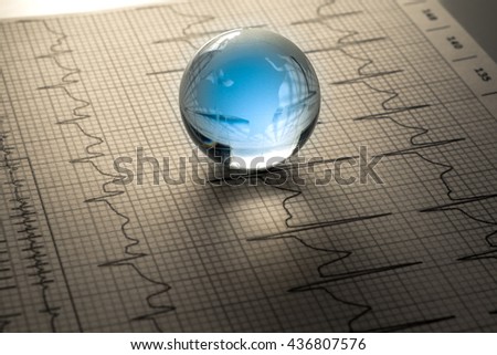 glass globe on EKG graph background
