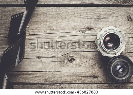 retro camera lenses and negative film on wooden table