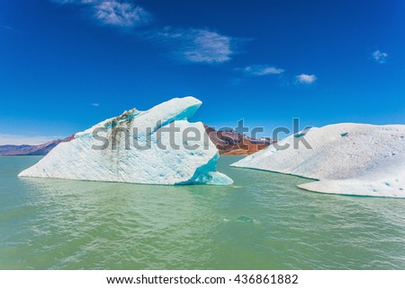  The huge white-blue iceberg drifts from coastal glacier in warm summer day. Argentina Patagonia, Lake Viedma