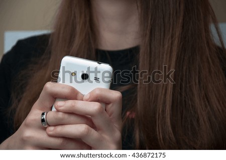 Girl holding a white smartphone. White background