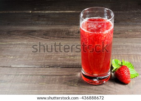 fresh strawberry juice with berry on old wooden background. summer drink