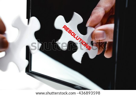 Hand holding puzzle in front of black folding mirror isolated on white with word Resolutions. Selective focus. Royalty-Free Stock Photo #436893598