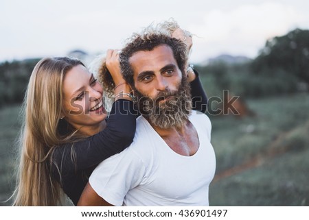 young happy couple posing in the nature, outdoor love portrait, kissing, man beard, girl blonde hair, hipster style, cute, smile