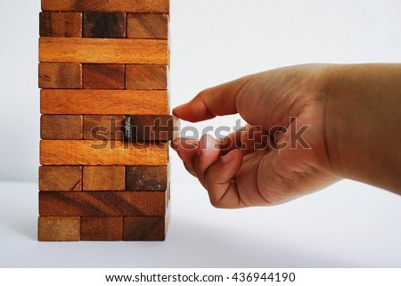 A woman playing the wood blocks,taking one out.For business background,For business concept or risk management concept.copy space.Soft focus.