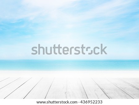 The blur cool sea background with wood floor foreground on horizon tropical sandy beach; relaxing outdoors vacation with heavenly mind view at a resort deck touching sunshine, sky surf summer clouds. Royalty-Free Stock Photo #436952233