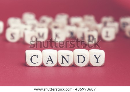 Candy word written on wood cube with red background