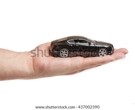 Black toy car in the men's hand on a white background. Car insurance. Automobile collision damage waiver concepts. with protective gesture and icon of car. Protection of car. Business concept.