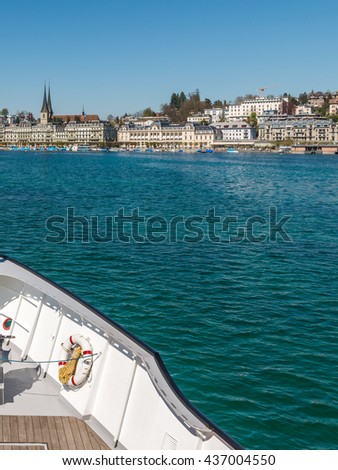 Ferry boat with red swiss flag on Lake Lucerne (Vierwaldstattersee) Switzerland. Motor Cruise Ship Waldstatter sail from Weggis under clear blue sky sunny day in summer with Lucerne skyline cityscape