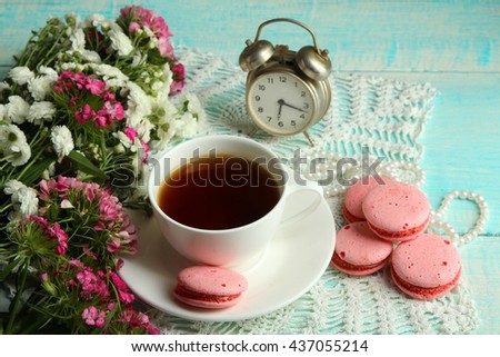 macaroons and chrysanthemum on white wooden background with Cup of tea