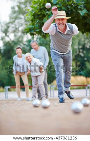 Man throwing ball while playing boule outside in a city Royalty-Free Stock Photo #437061256