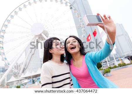 Woman using digital camera to take photo