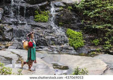 Beautiful Woman Dress in Hill tribe costume Lisu this photo take in a waterfall in national park in Chiang Mai Thailand
