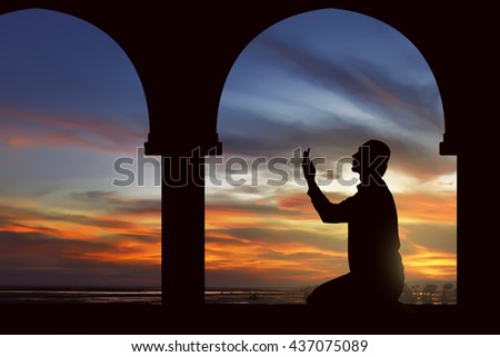 Image of silhouette man praying with mosque background