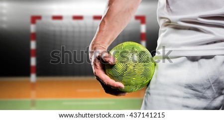 Sportsman holding a ball against digital image of handball goal