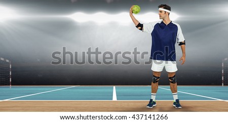 Sportsman posing with ball on white background against digital image of handball field indoor