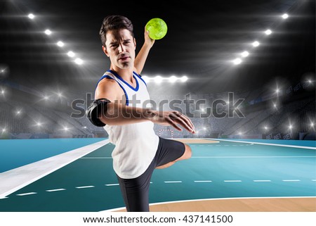 Portrait of athlete man throwing a ball against handball field indoor