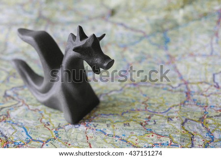 Dragon shaped paperweight on a blurred map of Slovenia country

