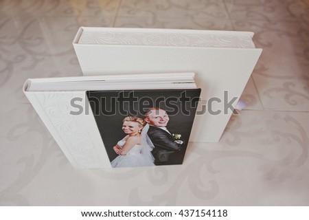 White leather wedding album with photo on canvas of newlyweds