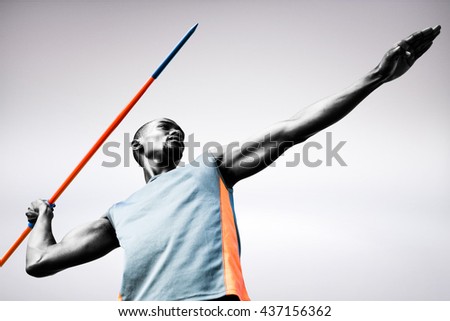 Low angle view of sportsman practising javelin throw against grey background Royalty-Free Stock Photo #437156362