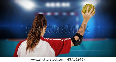 Sportswoman holding a ball against handball field indoor