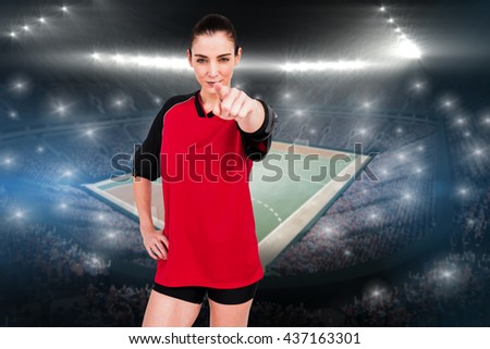 Female athlete pointing the camera against handball field indoor
