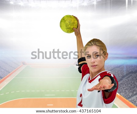 Sportswoman throwing a ball against handball field indoor
