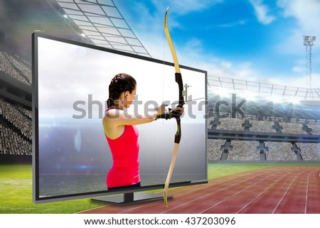 Side view of woman practicing archery against american football arena