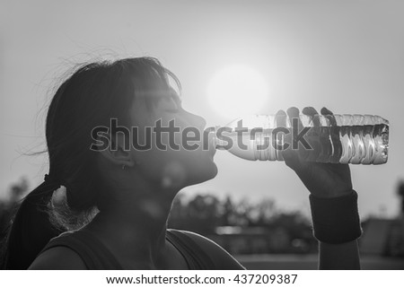 Female drinking a bottle of water. 