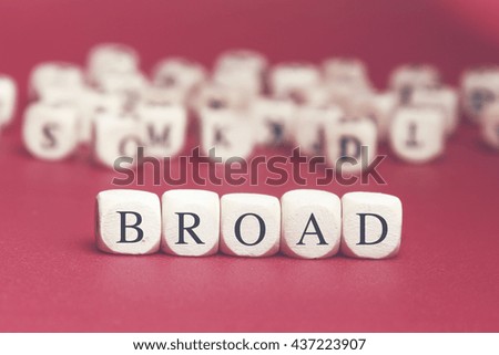 Broad word written on wood cube with red background