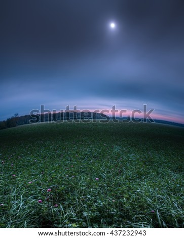 Large and empty clover filed at twilight, under full moon in light clouds, with last light of sunset on horizon. This picture is vertical panorama, stitched from two HDR images (5 exposures each).