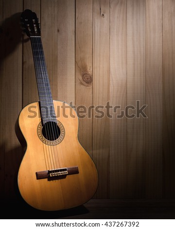 Classical guitar on wood background with copyspace.