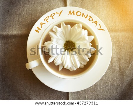 coffee cup on table with white daisy - Happy Monday word vintage style