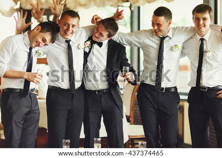 Groom and groomsmen have fun while posing in the restaurant Royalty-Free Stock Photo #437374465
