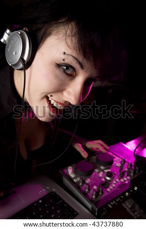 Girl with headphones working on DJ panel