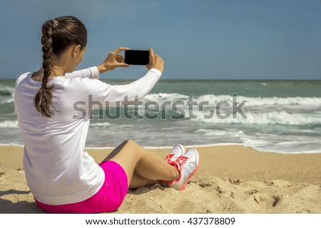 The girl on the beach makes selfie