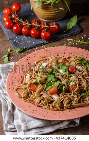 Spaghetti with mozzarella, cherry tomatoes and arugula, simple and delicious food