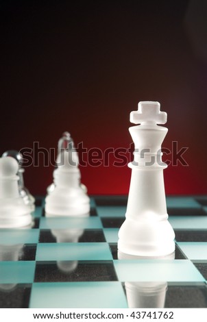Glass chessmen on a smooth surface dark background