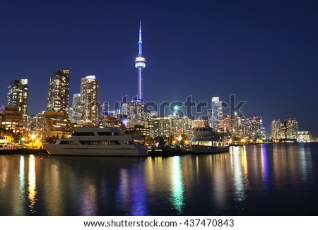 Toronto city skyline at night over lake with colorful reflections