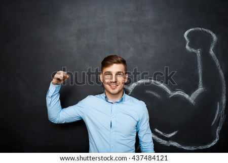 Picture of  funny suited business  man with  fake muscle arms over blackboard. hand whrite