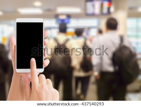 woman use mobile phone and blurred image of people in the airport terminal
