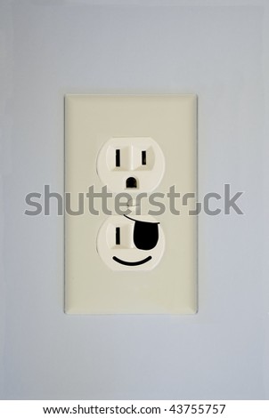 A standard wall electrical outlet contains two surprised faces. This one has one replaced by a pirate face.