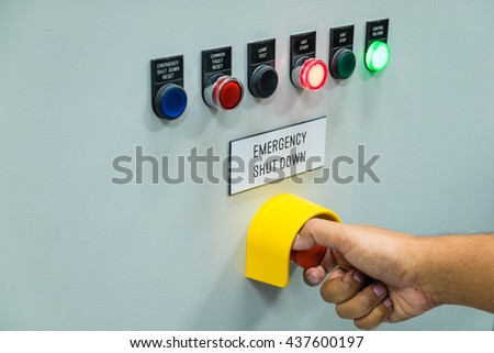 Technician is turning off emergency shutdown button on control panel in power plant