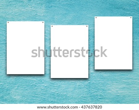 Close-up of three nailed blank frames on aqua weathered wall background