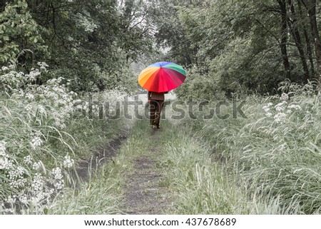 person with big colored umbrella walking in the forest landscape color reduced