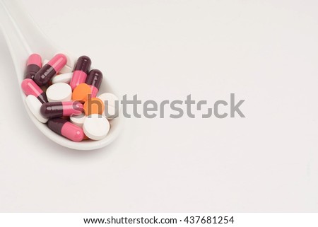 Assorted medicine in a spoon on white background. Selective focusing. Room for text on right.