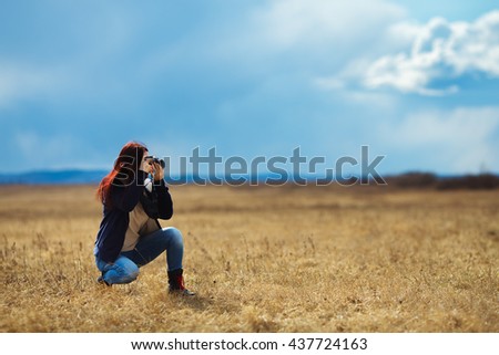 Happy traveler girl photographing field in bright sun rays, interesting profession, travel and tourism concept