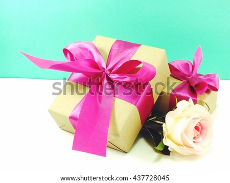gift box present with pink ribbon bow and beautiful flowers background