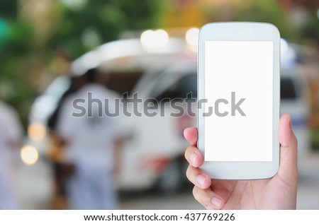 hand hold smartphone with Ambulance responding to emergency call background