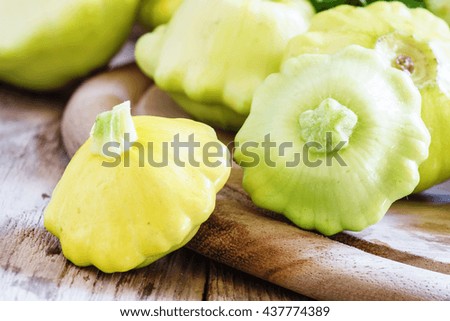 Pattypan or zucchini on old wooden table, rustic style, selective focus