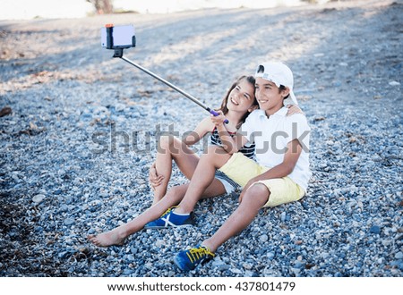 Boy and girl on the beach doing selfie